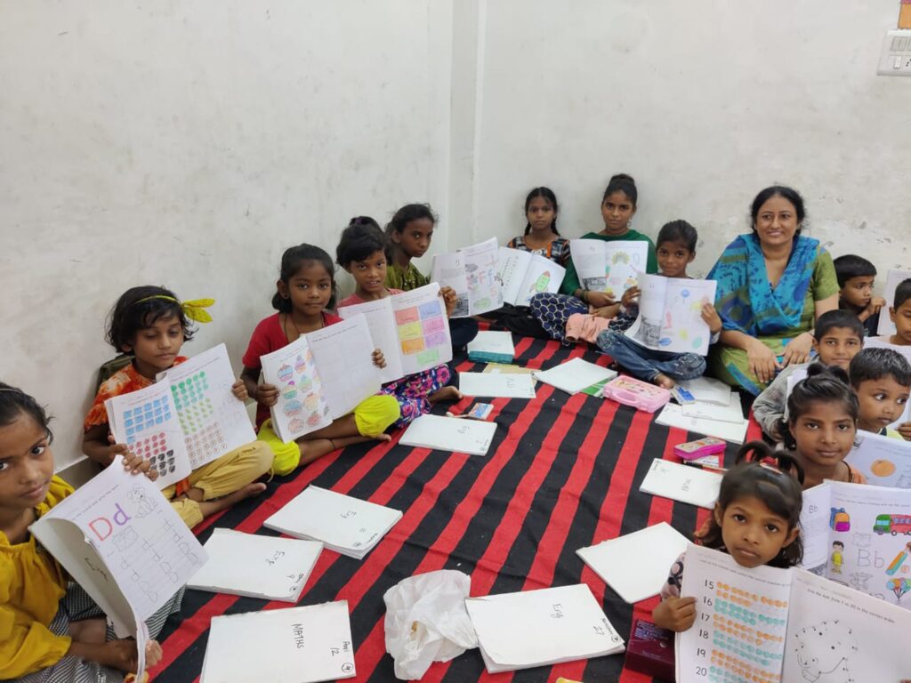 Glückliche Kinder in Indien zeigen stolz ihre farbenfrohen Klassenarbeiten.