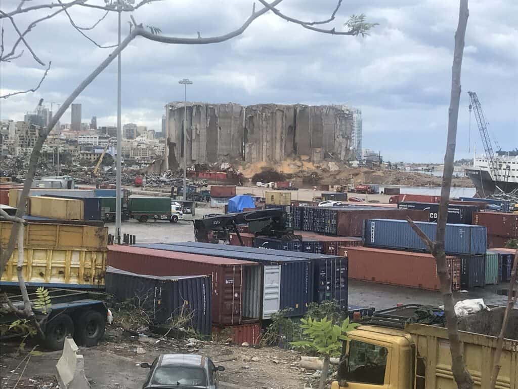 Beschädigte Getreidesilos im Hafen von Beirut nach der Explosion im Jahr 2020. Schiffscontainer und Trümmer umgeben das Gelände.