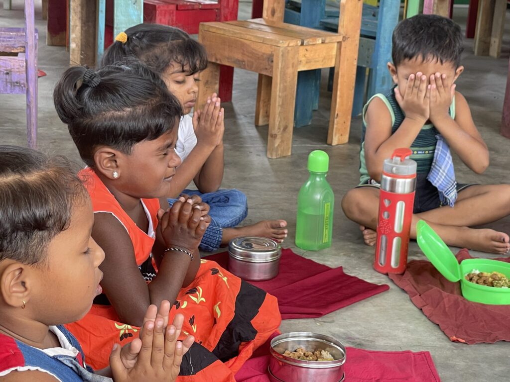 Kinder beten vor dem Essen in einer Schule in Sri Lanka.
