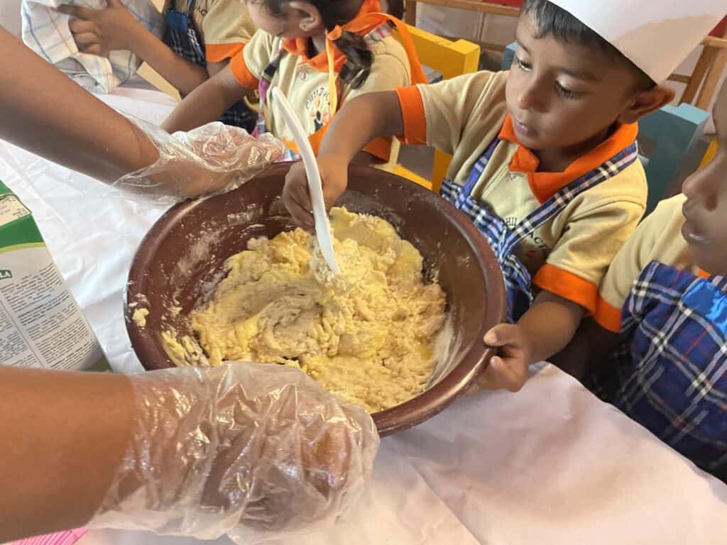 Vorschulkinder mischen Teig in einer Schüssel und lernen backen.