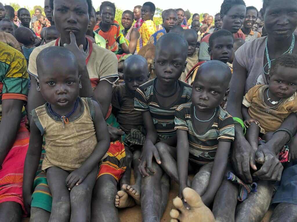 Eine Gruppe afrikanischer Kinder und Frauen sitzt zusammen.