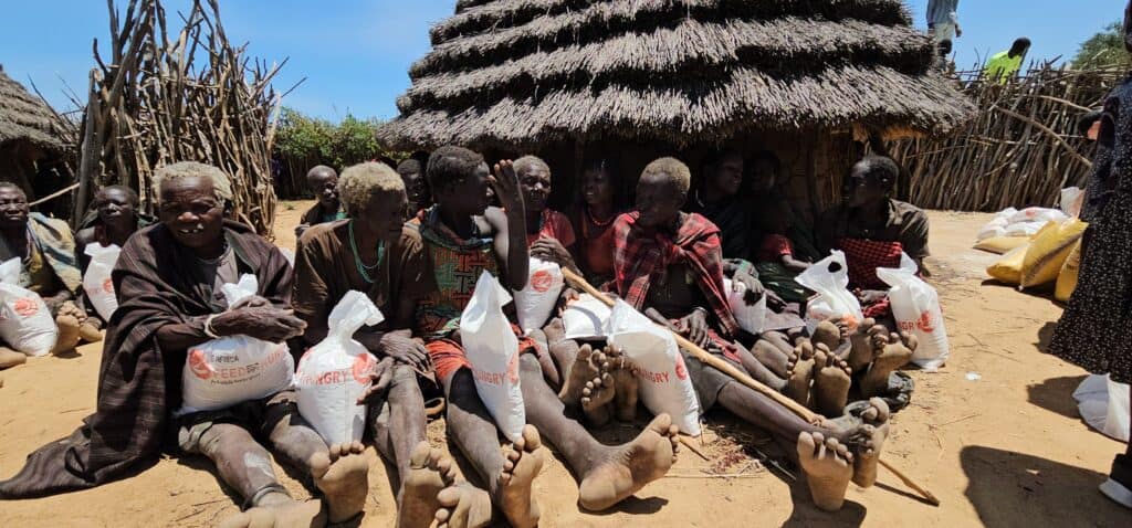 Die Menschen in einem Dorf erhalten Nahrungsmittelhilfe, Taschen mit der Aufschrift „Feed the Hungry“.