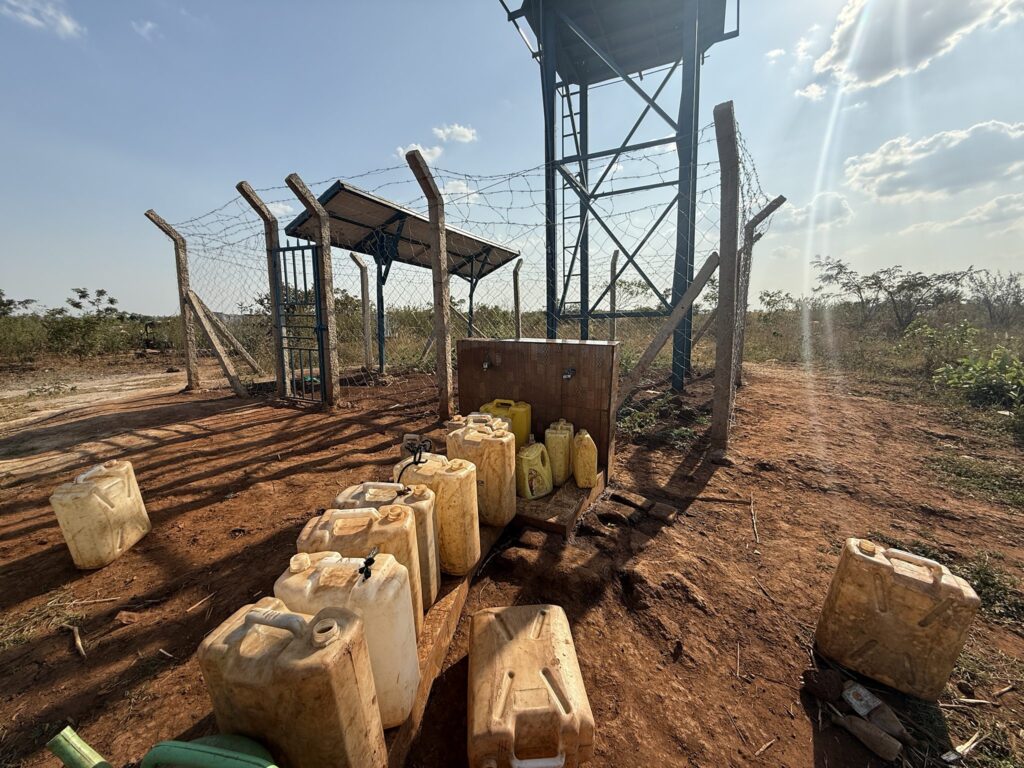 Wasserbehälter an einer ländlichen Wasserstelle mit Solarpanel und Wasserturm