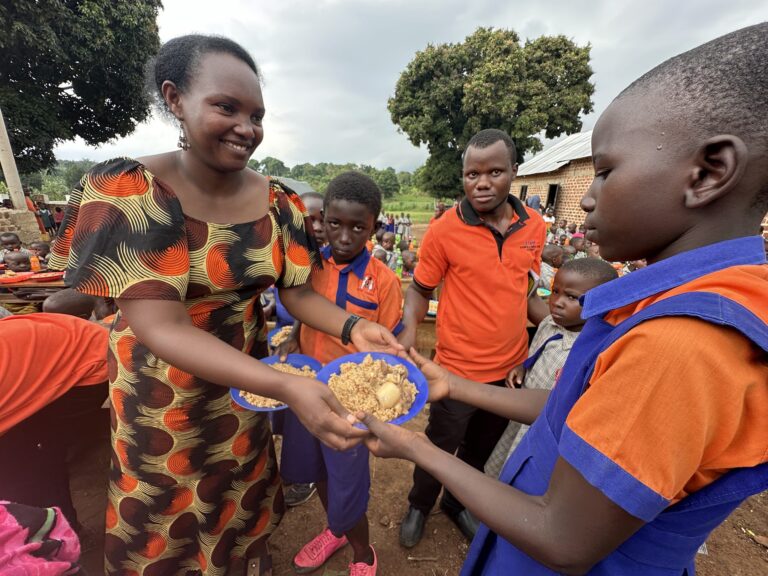 Frau serviert Kindern in Uganda eine nahrhafte Mahlzeit