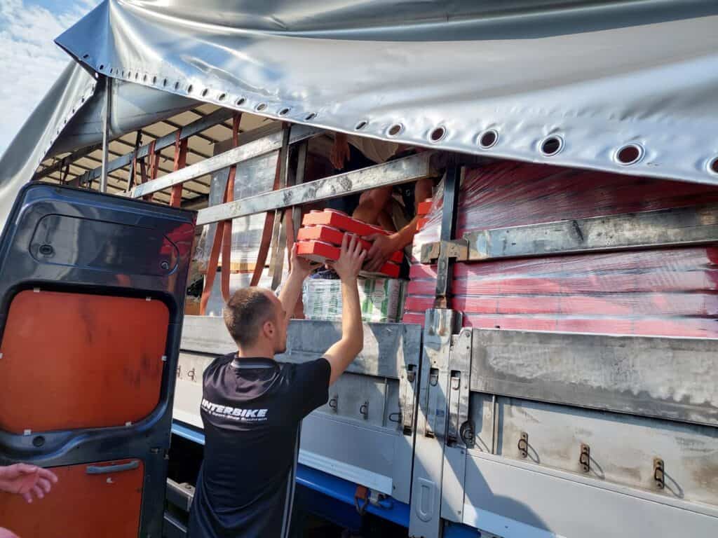 Arbeiter laden rote Kisten auf einen LKW, Logistik und Transport