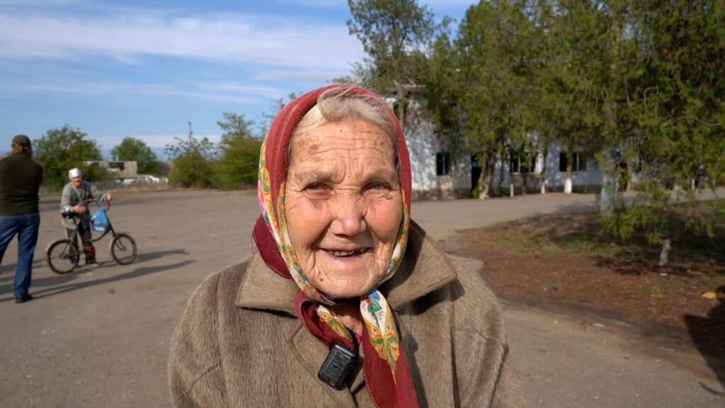 Lächelnde ältere Frau mit Kopftuch, im Freien