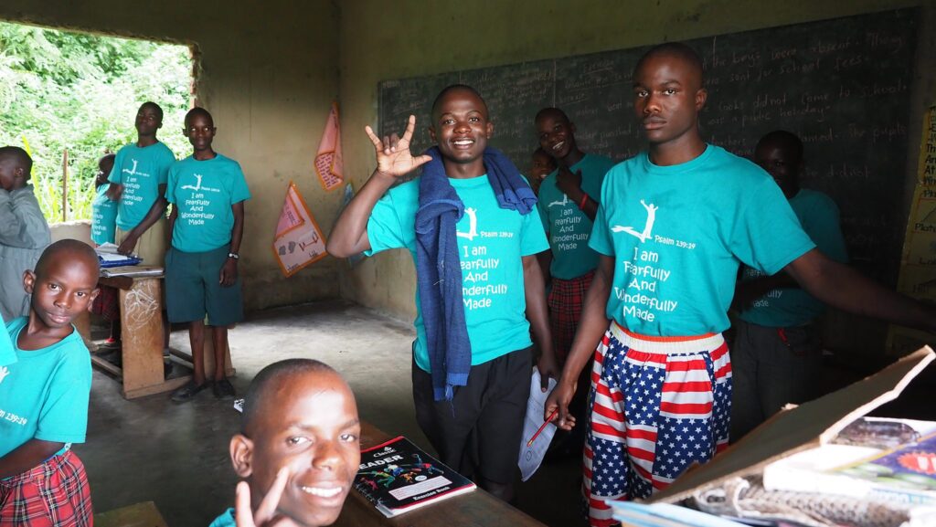 Afrikanische Kinder in einem Klassenzimmer tragen T-Shirts mit der Aufschrift „Ich bin furchtbar und wunderbar gemacht“.